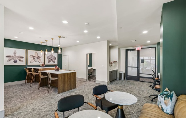 A room with a green wall and a white ceiling with a table and chairs.