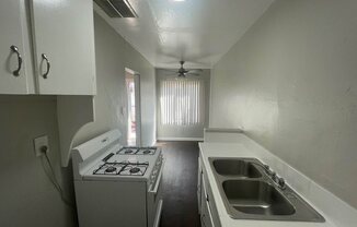 an empty kitchen with a stove and a sink