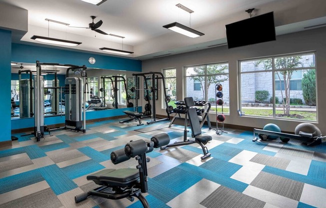 a gym with weights and cardio equipment in a multifamily building