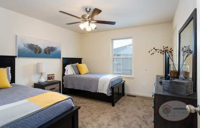 a bedroom with two beds and a ceiling fan