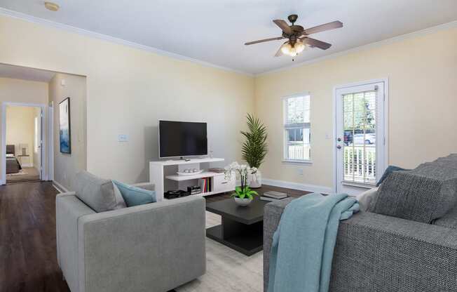 Living room with wood-designed flooring and door to balcony at Adrian on Riverside in Macon, GA
