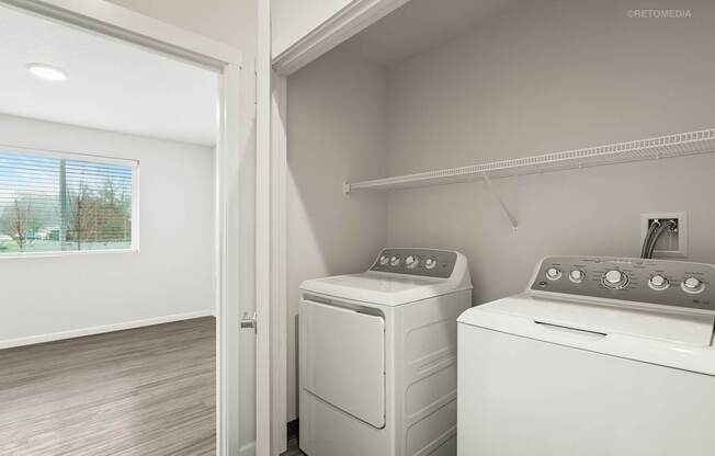 A white dryer and washer are sitting next to each other in a small laundry room.
