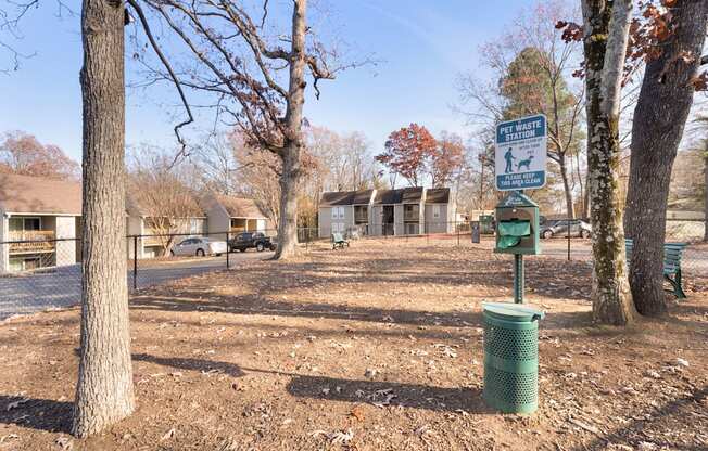 A sign in a park indicates a pet-friendly area.