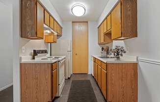 A kitchen with wooden cabinets and a white stove top oven.