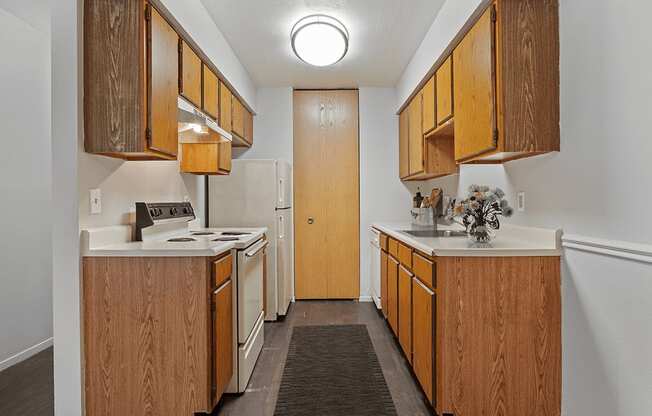 A kitchen with wooden cabinets and a white stove top oven.
