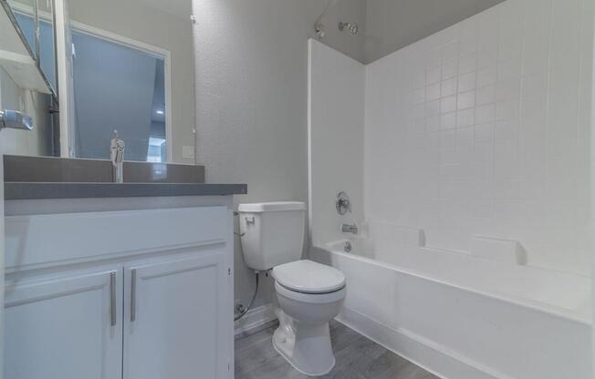 a bathroom with a toilet and a tub and a sink at Warner Center Townhomes, California 