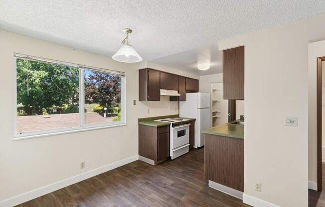 A kitchen with white appliances and brown cabinets.
