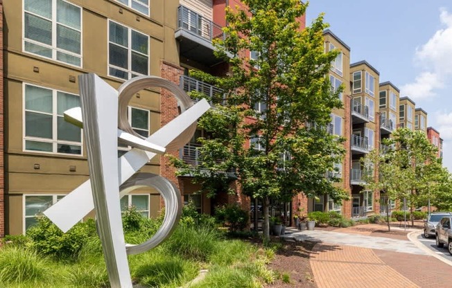 A large white sculpture in front of apartment buildings.