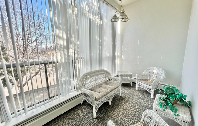 Relax in this charming sunlit space featuring elegant wicker seating.