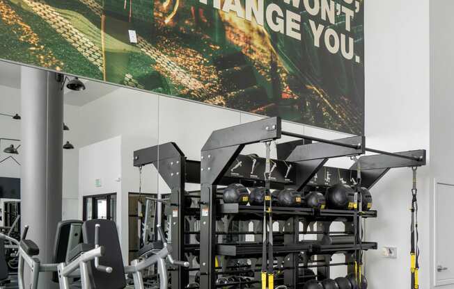 a gym with weights and a poster on the wall