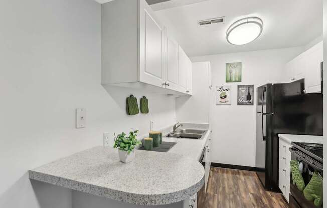 A kitchen with a granite countertop and white cabinets.