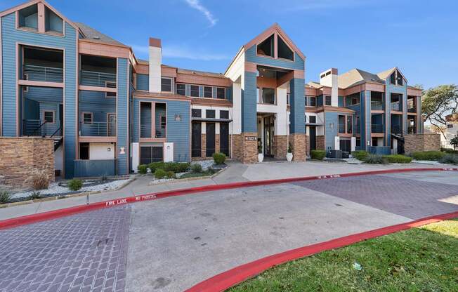 A row of modern buildings with a red brick pathway in front.