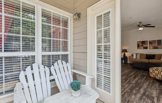 a living room with a table and chairs and windows