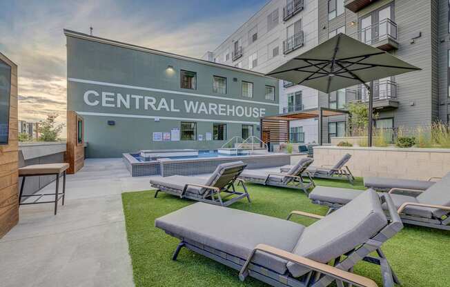 furnished patio with lounge chairs and umbrellas at the central warehouse apartments