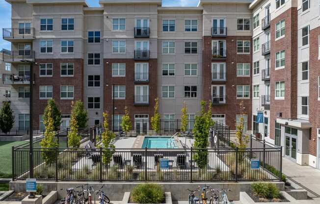 an apartment building with a pool and bikes parked in front of it