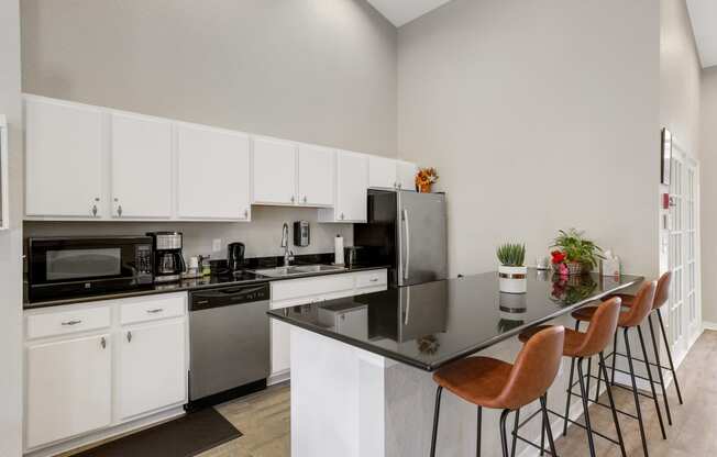 a kitchen with white cabinetry and black countertops