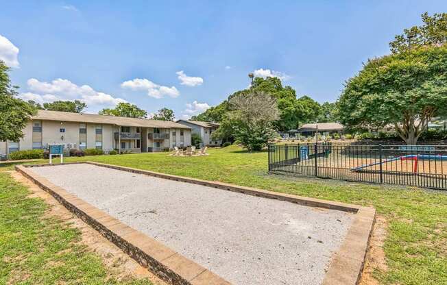 A residential area with a basketball court and a fence.