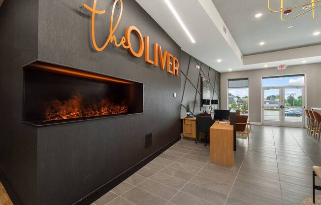 A modern lobby with a fireplace and a sign that says "The Oliver".