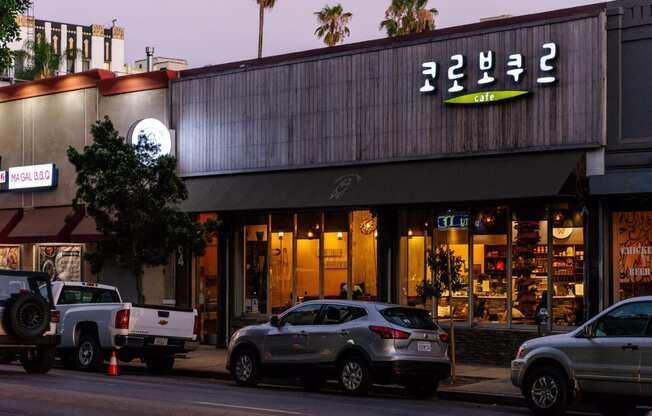 a city street with cars parked in front of a store