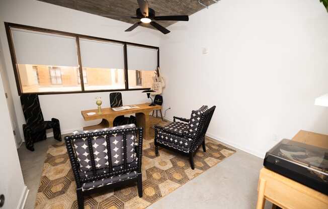 a living room with two chairs and a desk and a ceiling fan  at The Lady, South Carolina, 29201