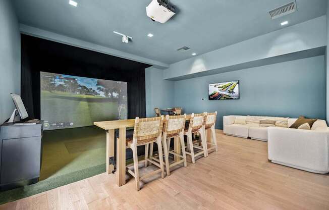 A room with a table and chairs and a television on the wall.