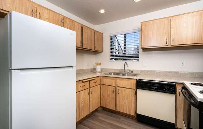 A kitchen with wooden cabinets and a white refrigerator.
