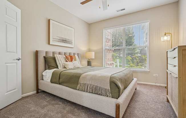A bedroom with a large bed and a ceiling fan.