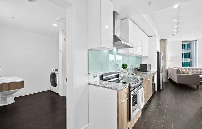 A modern kitchen with white appliances and wooden cabinets.