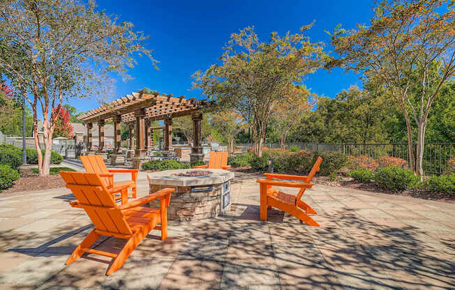 A patio with orange chairs and a gazebo.