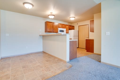 a kitchen and living room with a microwave and a refrigerator