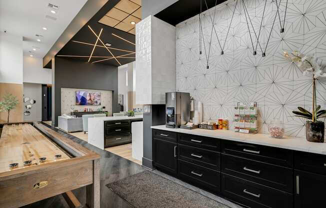 a large kitchen with black cabinets and white countertops and a large wooden table with a shuffle at Prism at Diamond Ridge, Pennsylvania
