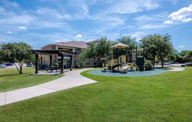 a playground in a park with a building in the background