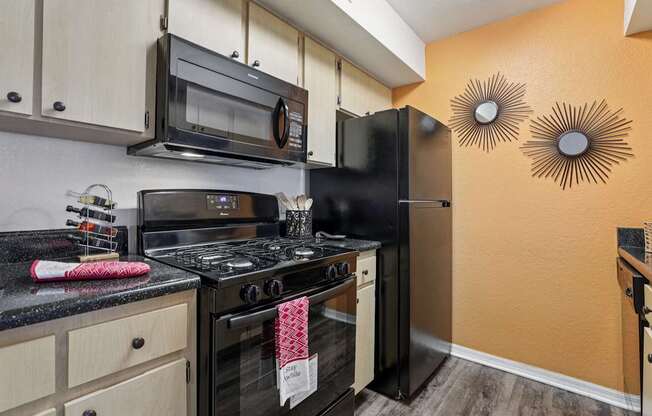 A kitchen with black appliances and wooden cabinets.