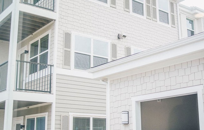 the exterior of a white house with a black garage door