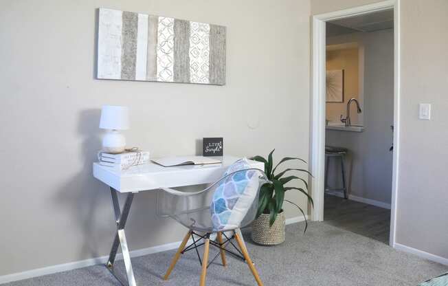 a home office with a desk and a chair and a potted plant