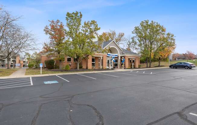 an empty parking lot in front of a brick building with a car parked in front