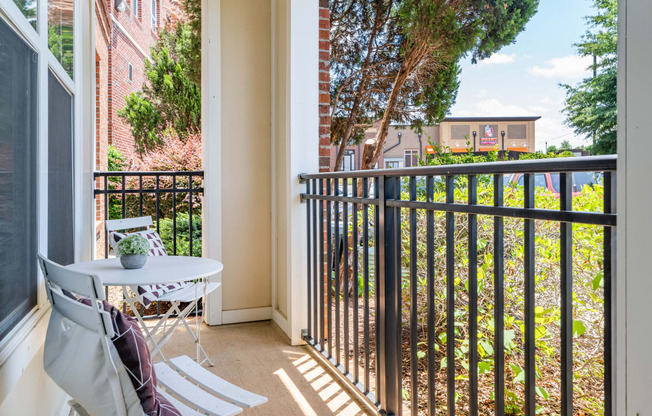 a balcony with a small table and chairs and a window