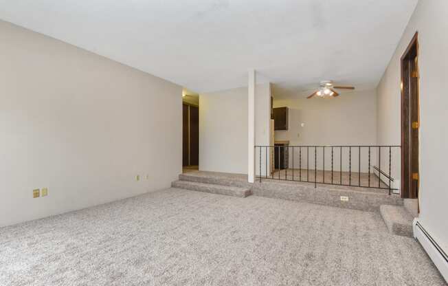 the living room of an empty house with carpet and a ceiling fan. Roseville, MN Rosedale Estates