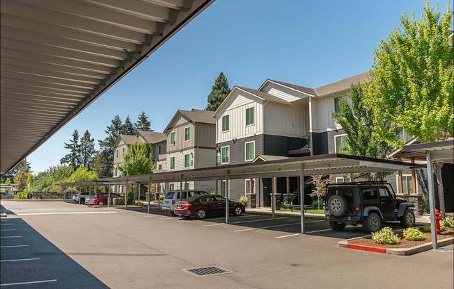 A parking lot with cars and a building in the background at Forestplace Apartment Homes, Oregon, 97116
