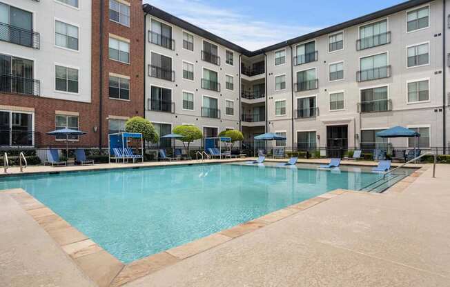 A large swimming pool surrounded by apartment buildings.