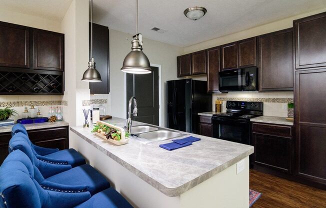 a kitchen with black appliances and a white counter top