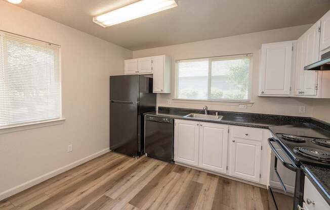 A kitchen with black appliances and white cabinets at Autumn Oaks Apartments, Roseville, CA, 95678