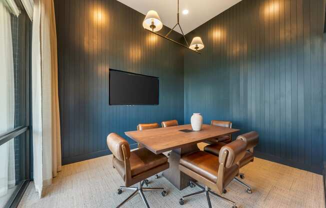 a conference room with a table and chairs and a tv