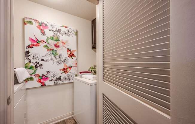 A small bathroom with a floral print towel hanging on the wall.