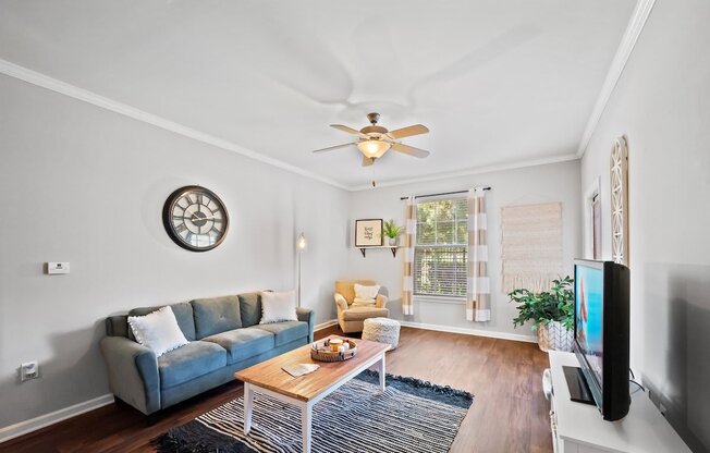 a living room with a couch coffee table and a ceiling fan