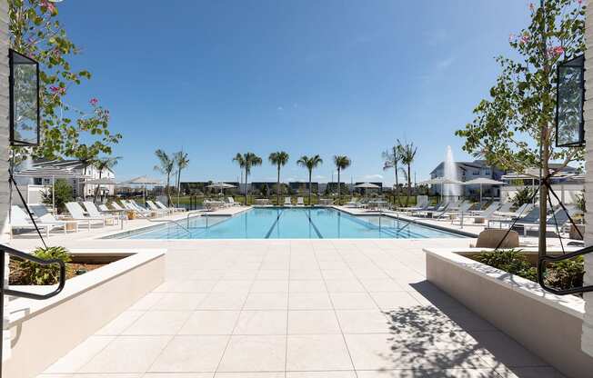 a swimming pool with chaise lounge chairs and trees at Lake Nona Concorde