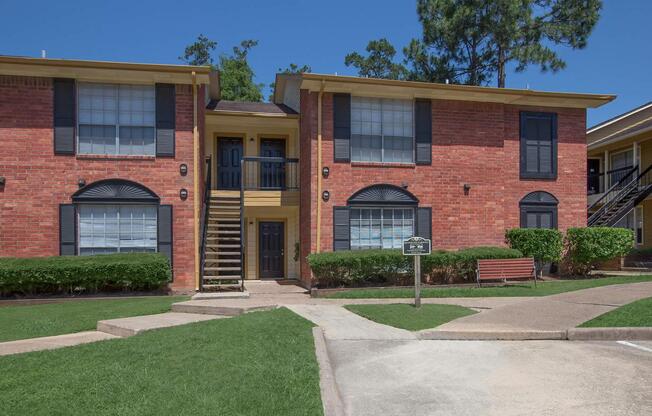 a large brick building with grass in front of a house