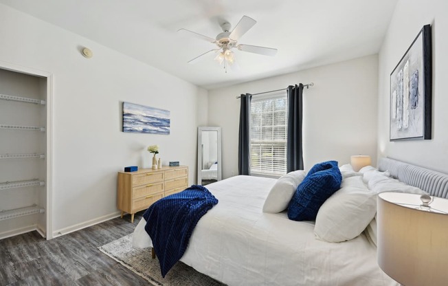 a bedroom with a large bed and a ceiling fan