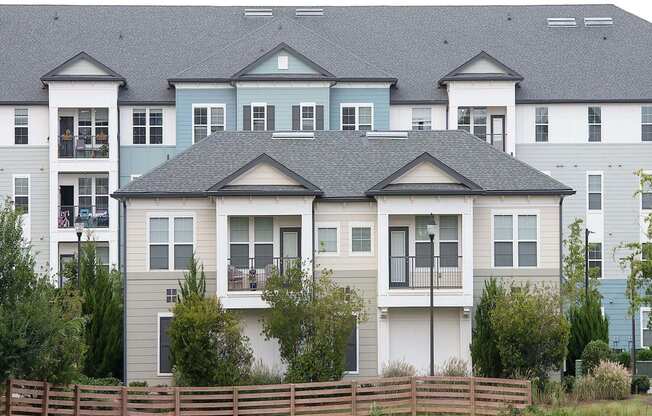 a row of town houses with a fence in front of them