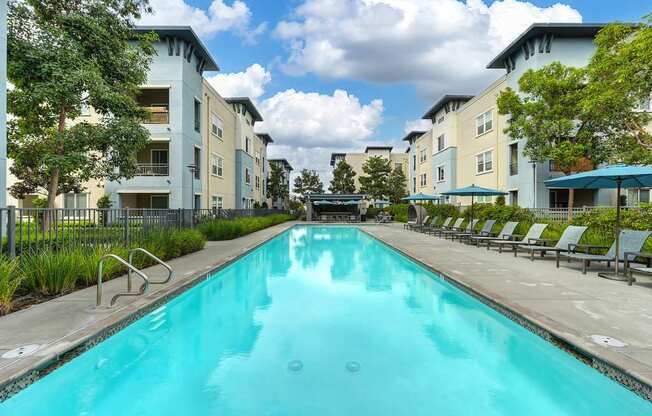 A swimming pool in front of apartment buildings.